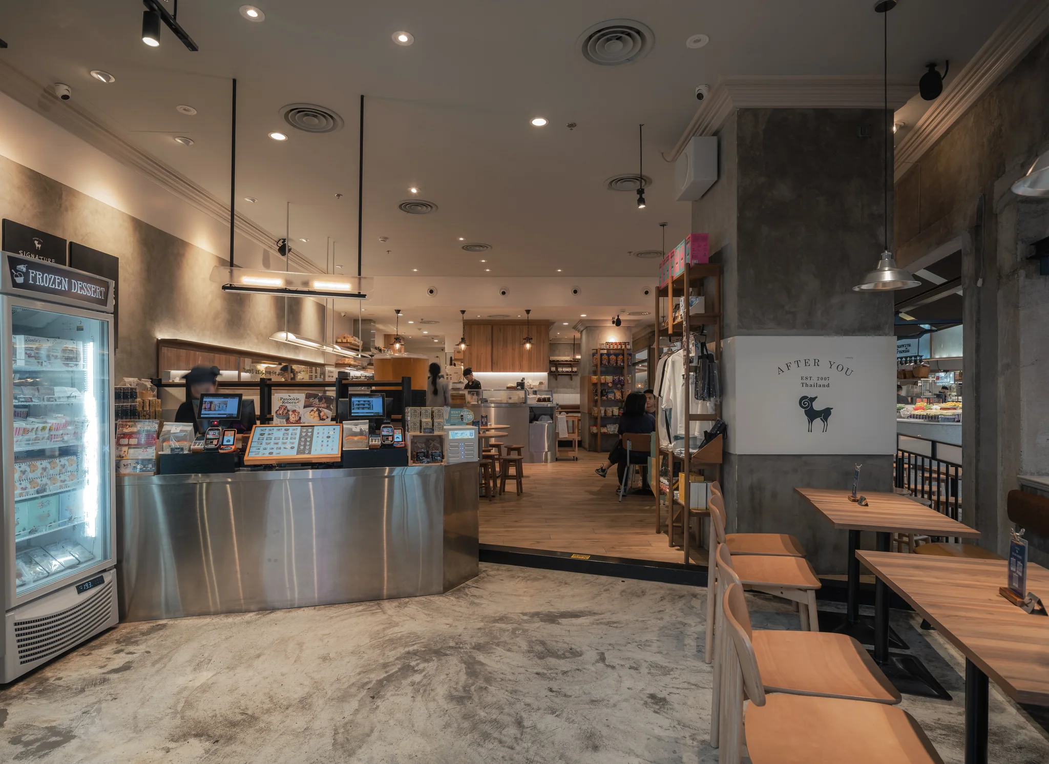 View from the entrance past the curved metal ordering counter into the dining room.