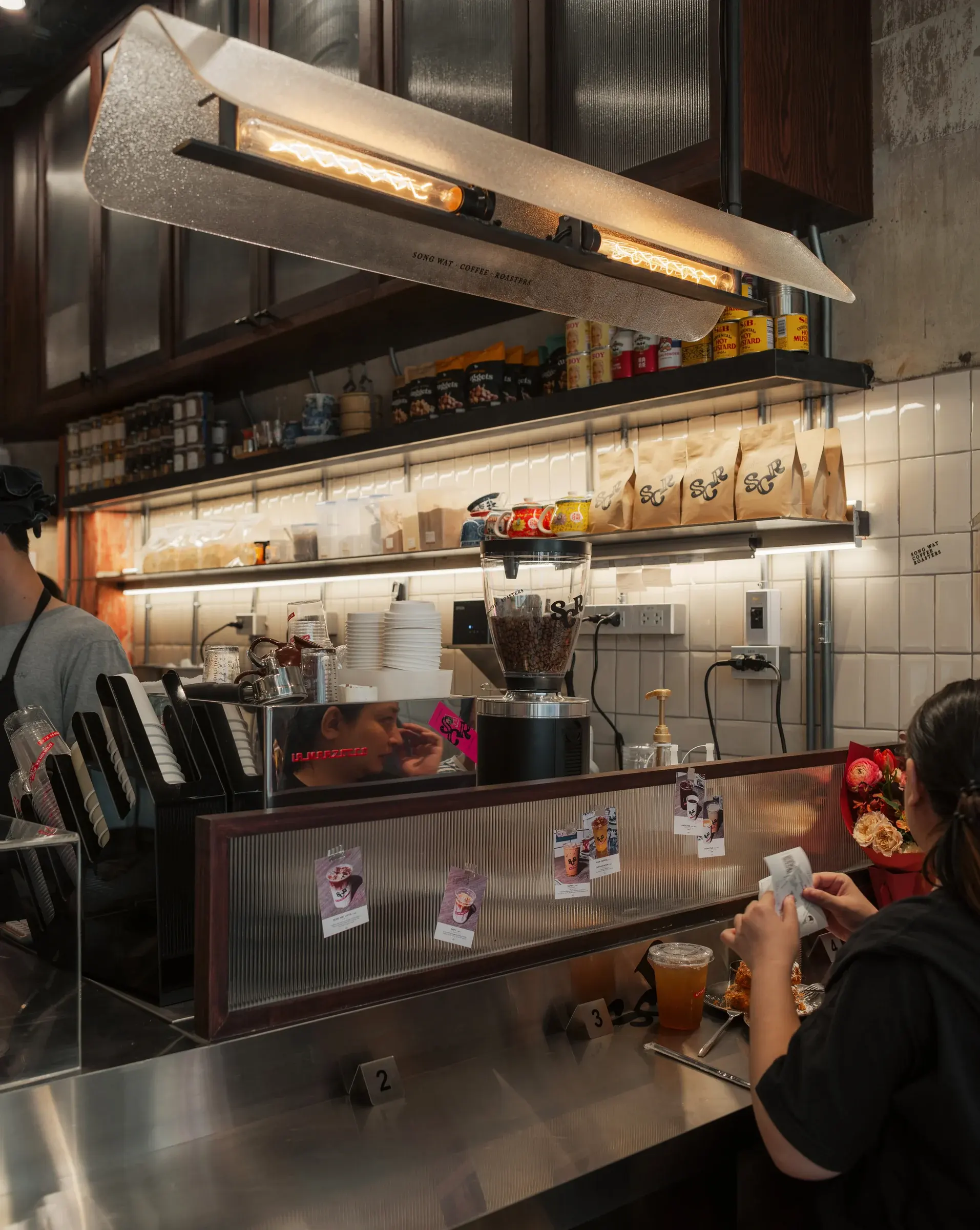 Service counter with metal shelving and white tile at After You Chinatown