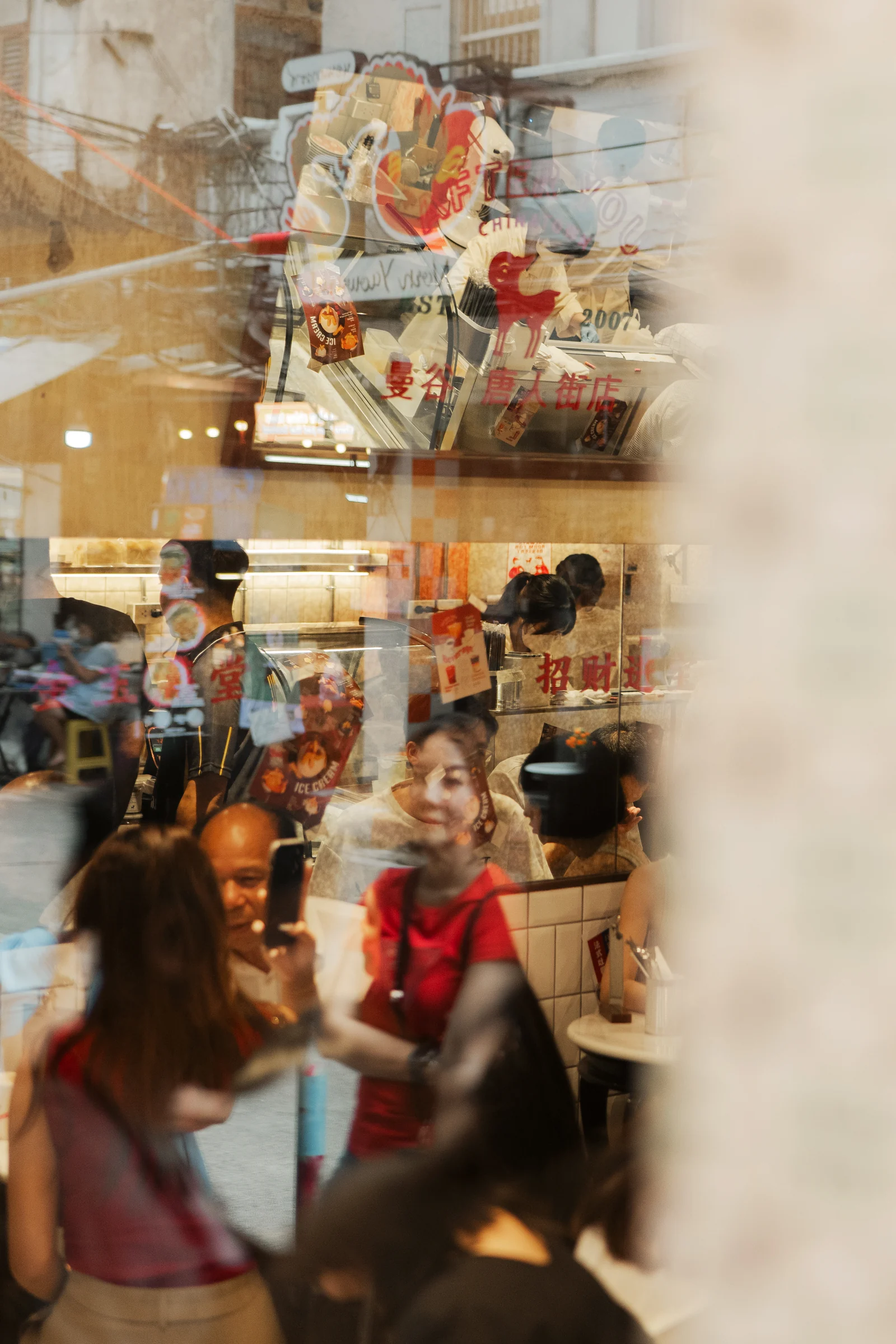 Customers and staff seen through the Chinatown shop window