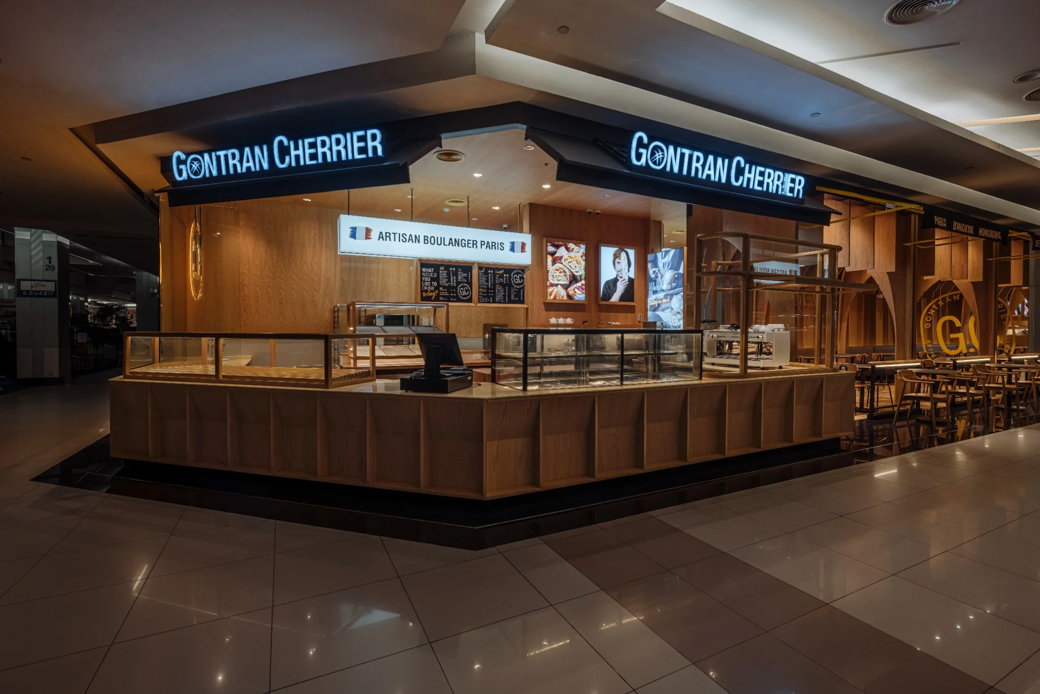 Cafe seating beneath repeated timber arches at Gontran Cherrier