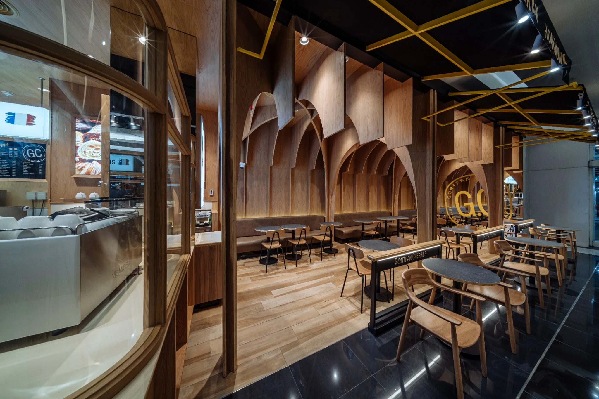 Cafe seating zone with warm timber and pale surfaces