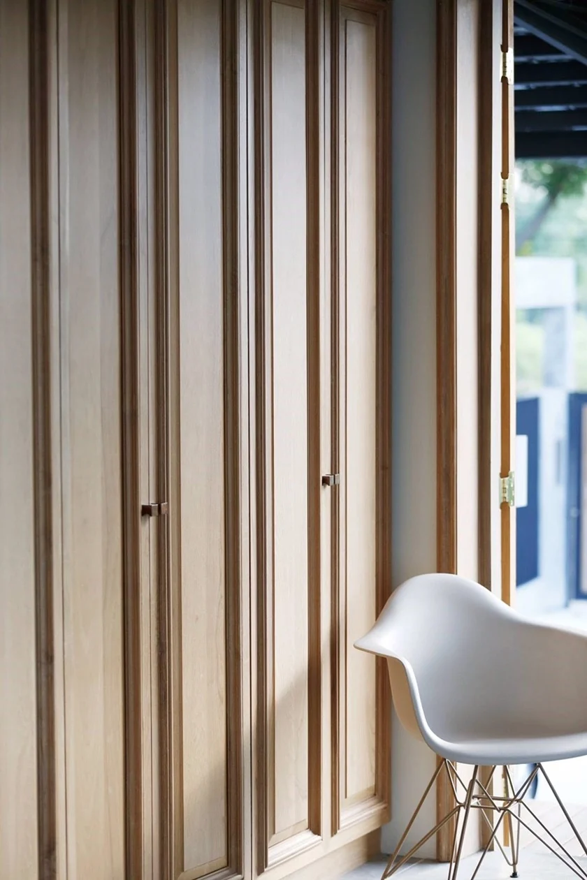 Timber cabinetry and white chair at Kitisook House