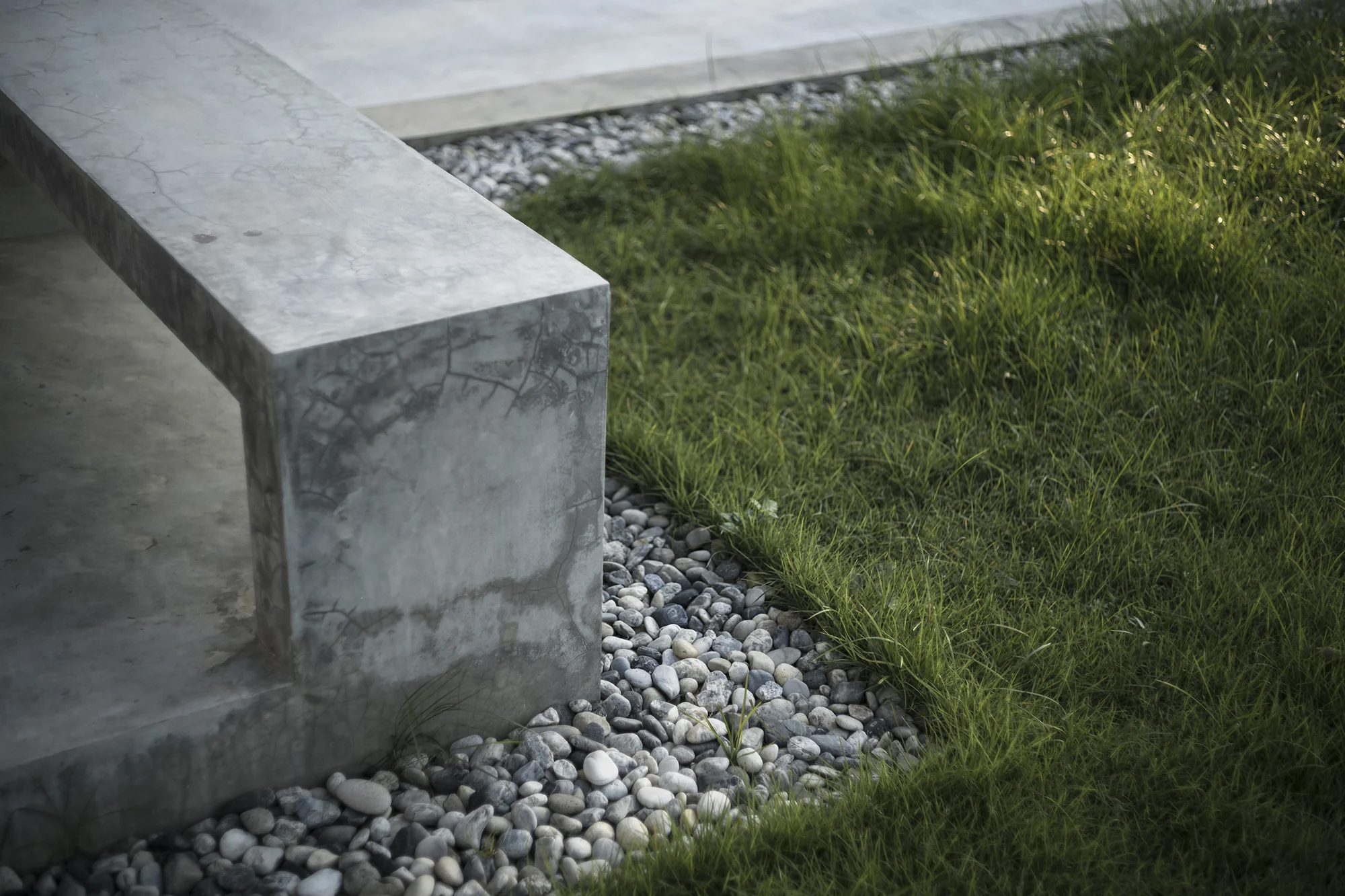 Concrete garden bench, pebbles and planting at Kitisook House