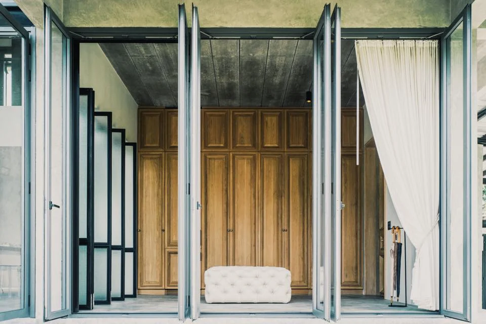 Kitisook House bedroom opened to the terrace through folding glass doors