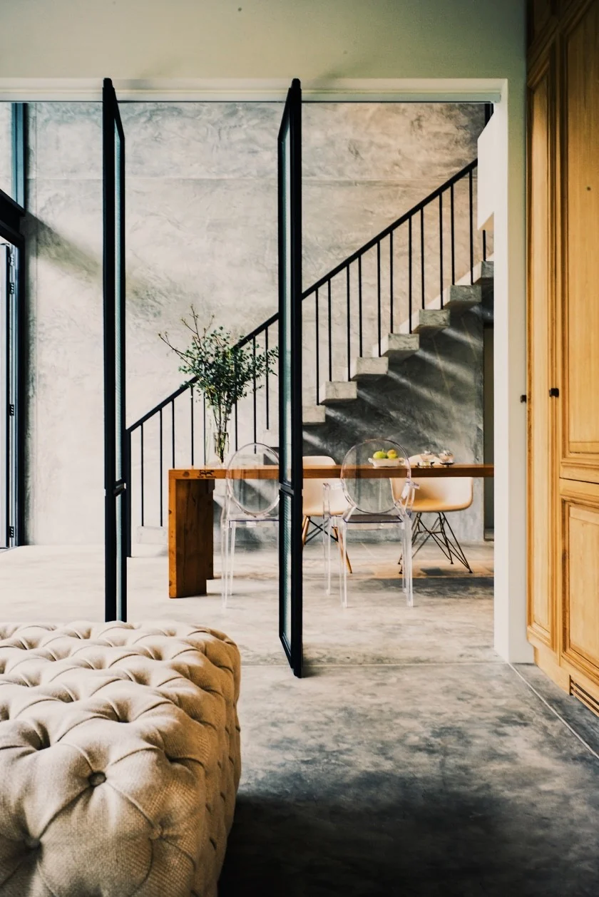 View from the bedroom through folding doors to the dining room and concrete stair