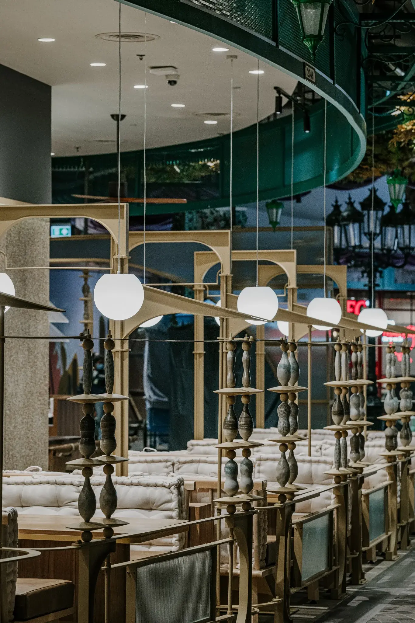 Repeated arched frames, globe lights and ceramic details at Ponn Terminal 21 Rama 3