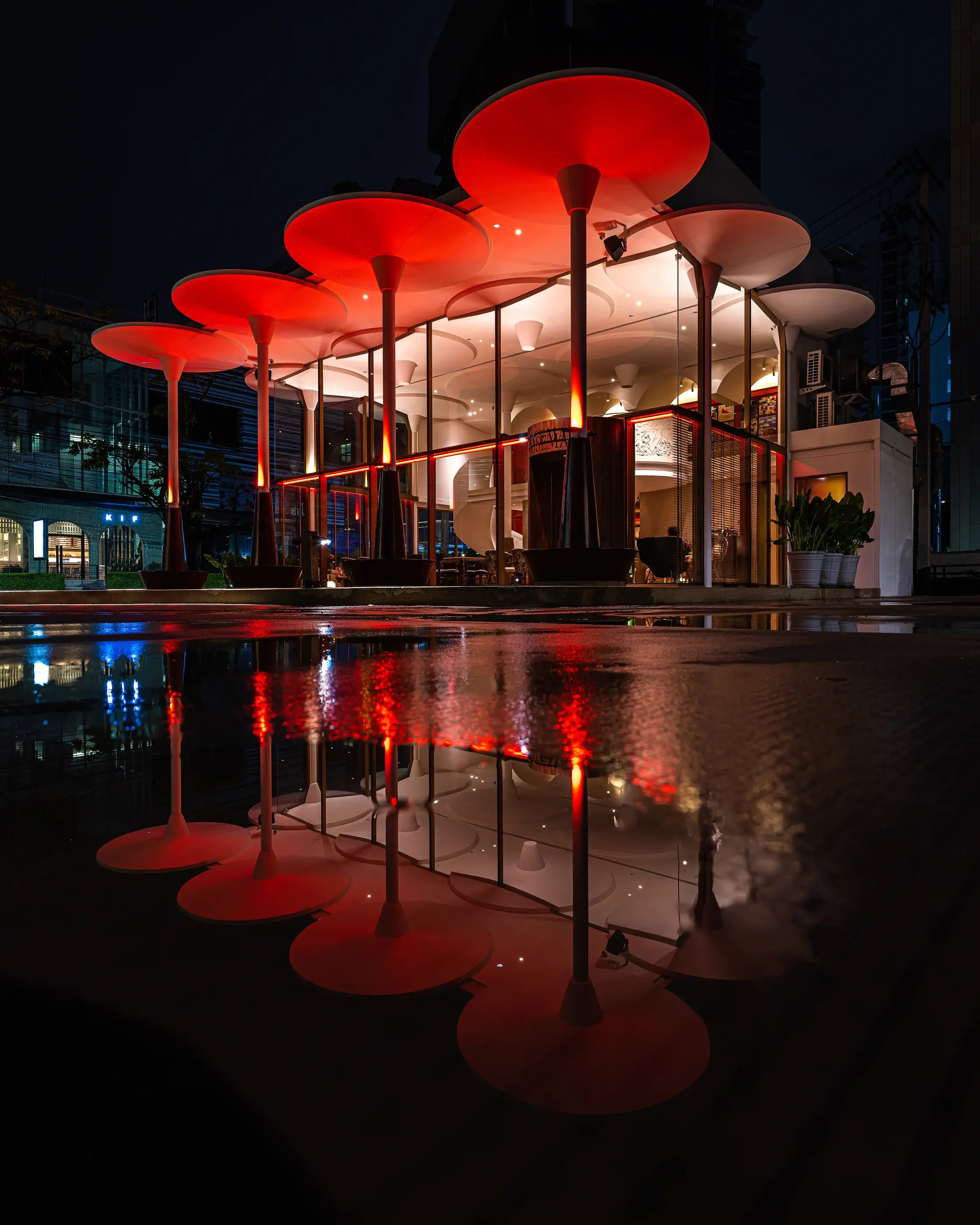 Night exterior of Rosemary Everyday Brasserie with red lighting reflected on the pavement