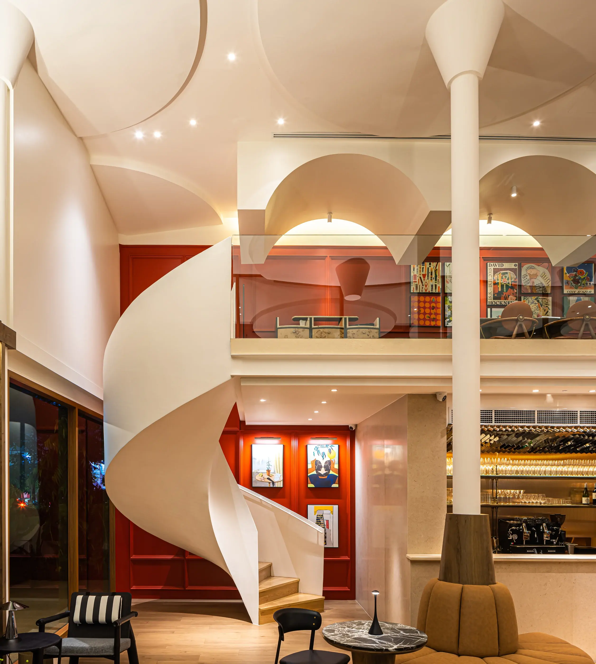 Interior lounge at Rosemary with the white spiral stair rising behind custom seating