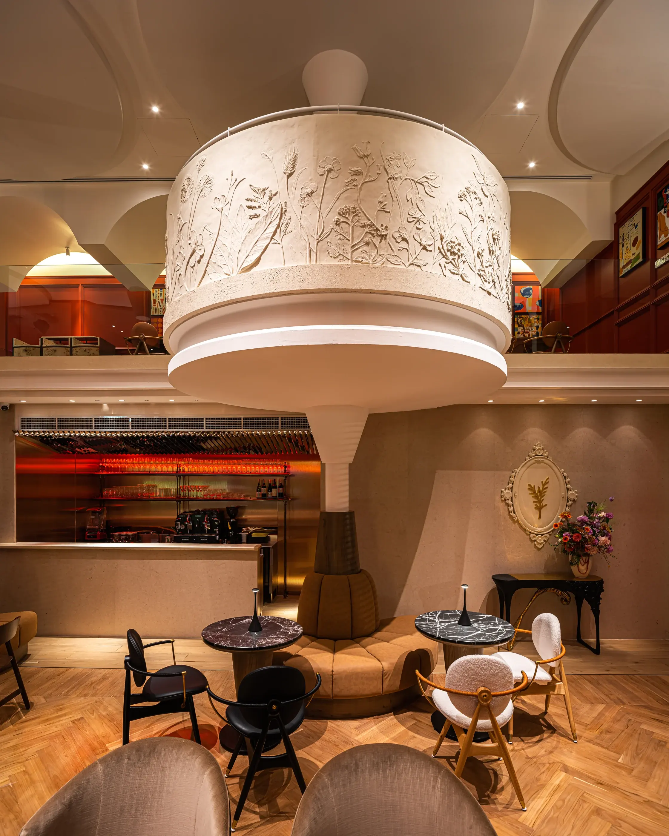 Rosemary mezzanine and botanical plaster relief above the ground-floor bar