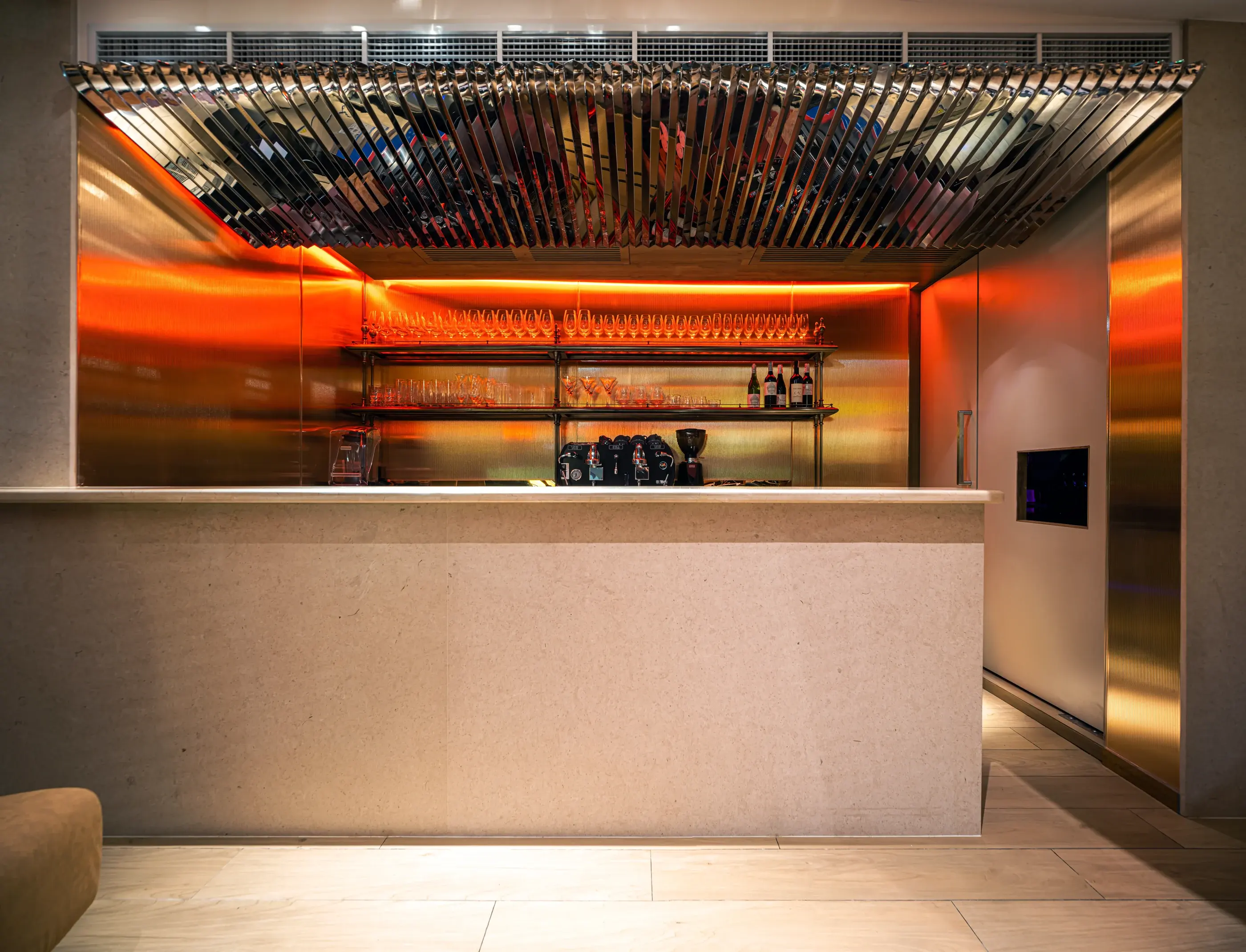 Rosemary service bar with reflective metal canopy and warm red illumination