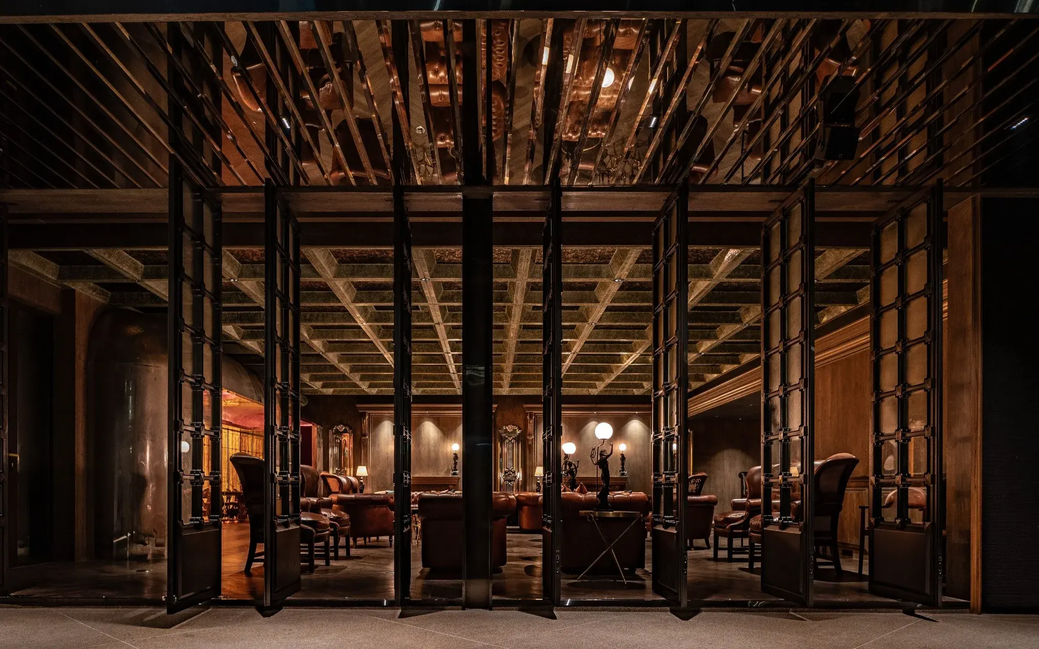 Arrival sequence inside The Club with layered lighting and dark materials