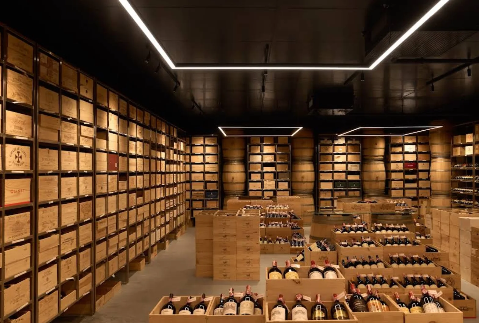 Wide interior view of Wine Gallery Bangkok with illuminated wine crate walls and central bottle displays