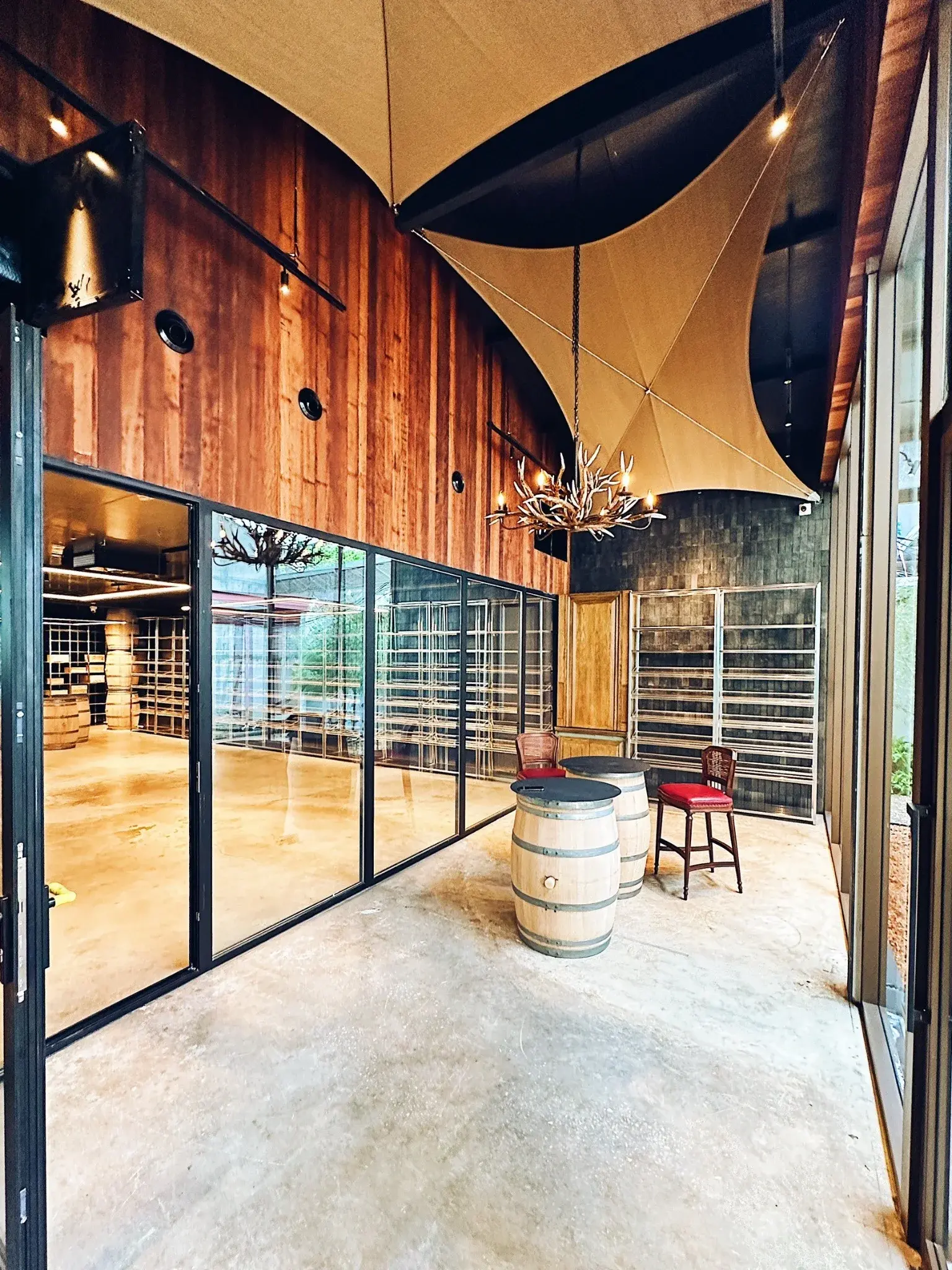 Wine Gallery Bangkok tasting room with timber walls, glass partitions, fabric canopy and barrel tables
