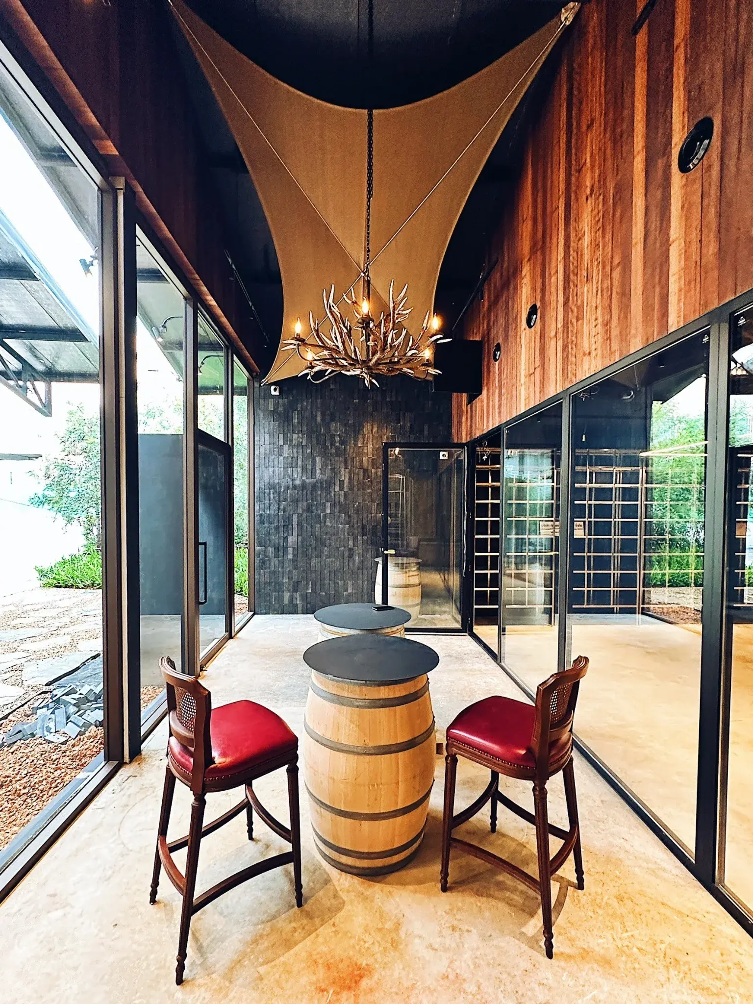 Barrel table and red leather chairs in the Wine Gallery Bangkok tasting room